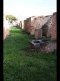 02310 ostia - regio v - insula xi - portico del monumento repubblicano (v,xi,4) - porticus - im vordergrund - edificio (v,xi,3) - bli ri osten - 01-2024.jpg